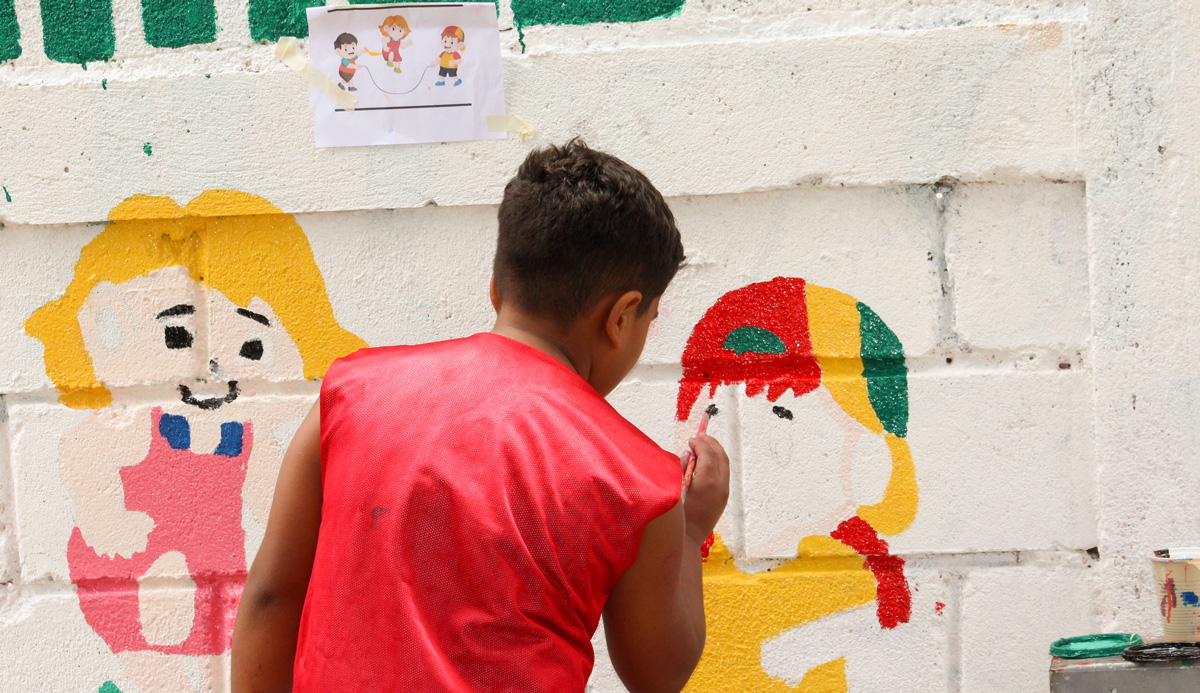 Niños pintan mural